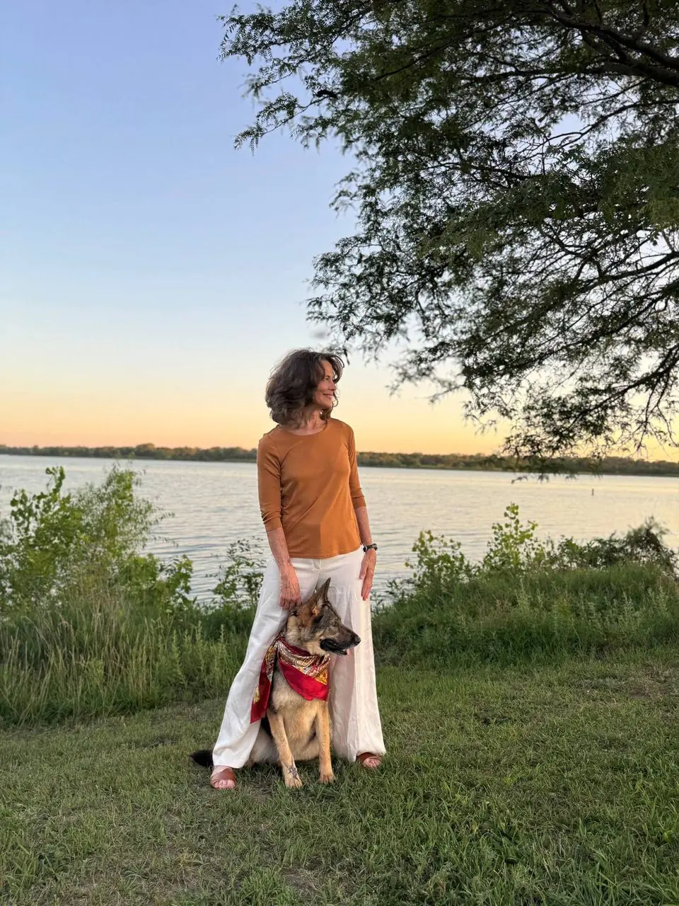 La Dra. Whiting con su perro junto al lago al atardecer.